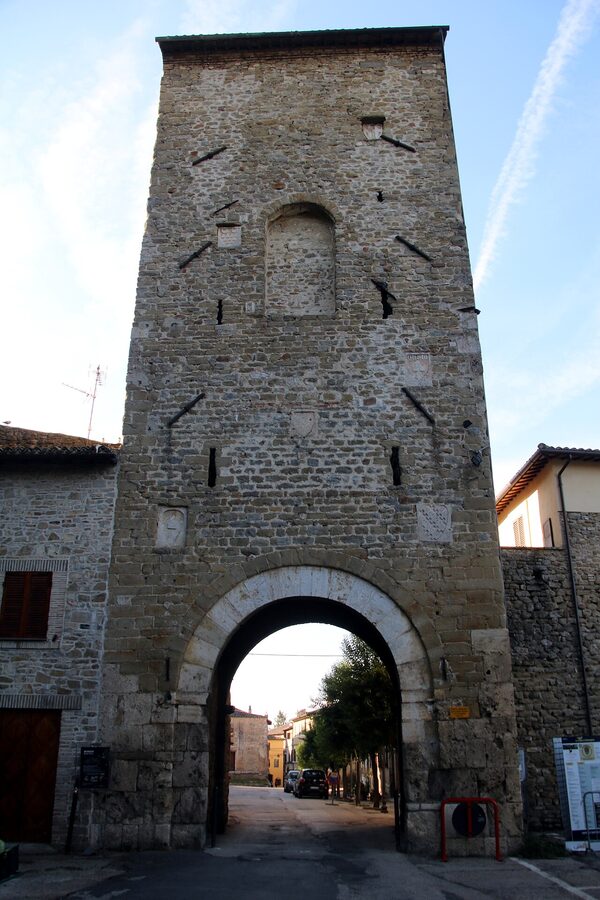 Porta Cannara, a medieval stone gate in the walls of Bevagna, with wrought-iron decorations