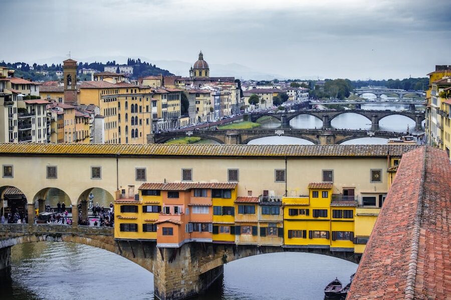 Ponte Vecchio spanning the Arno river in Florence with overhanging shops in golden evening light