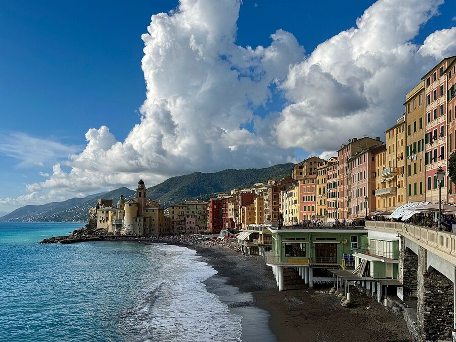 Camogli on the Golfo Paradiso with tall pastel houses, fishing boats and the promontory of Portofino in the distance