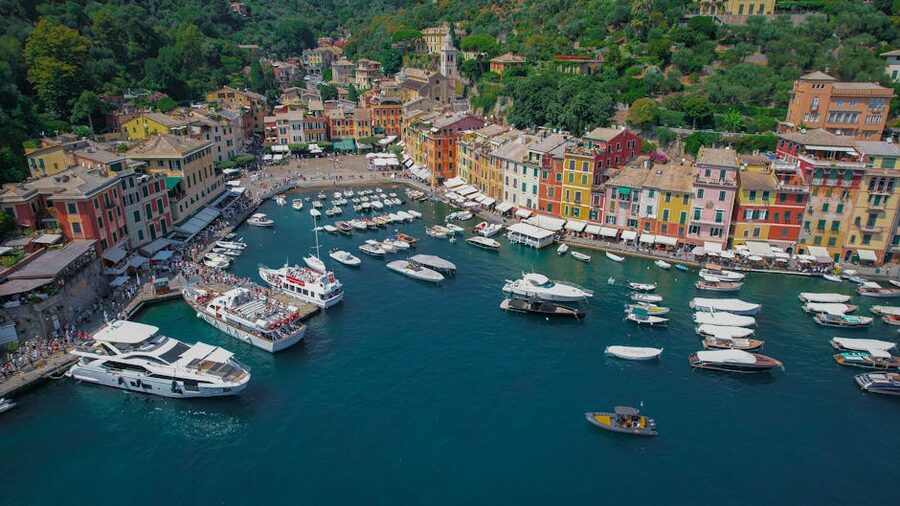 Aerial view of Portofino's colourful harbour with yachts, pastel waterfront buildings, and green hills