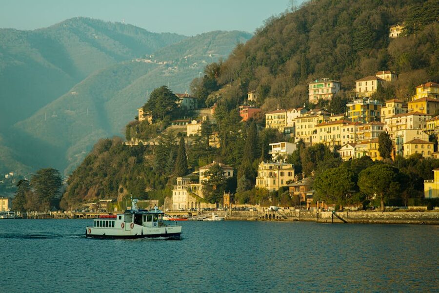 Lake Como with colorful houses on the hillside and a ferry boat on the blue water