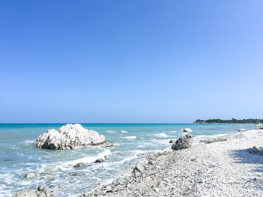 The beach at Numana on the Riviera del Conero, Marche, with parasols and the limestone headland behind