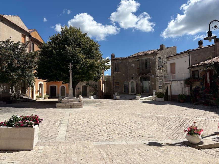 A quiet Molise town piazza with historic architecture and bright summer flowers