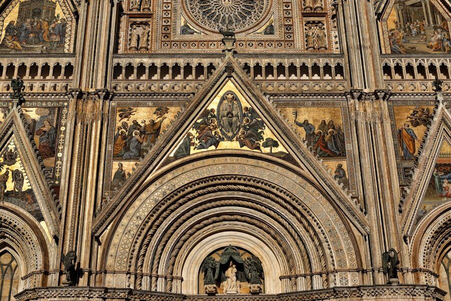 Close-up of the striped marble façade of Orvieto Duomo with Gothic arches and mosaic details