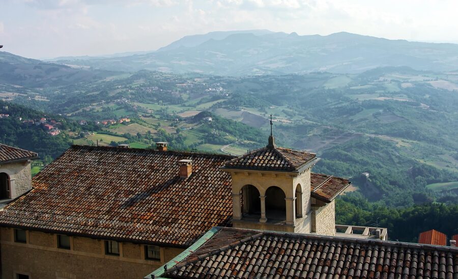 Panoramic view of the San Marino countryside showing a convent and medieval buildings on green hills