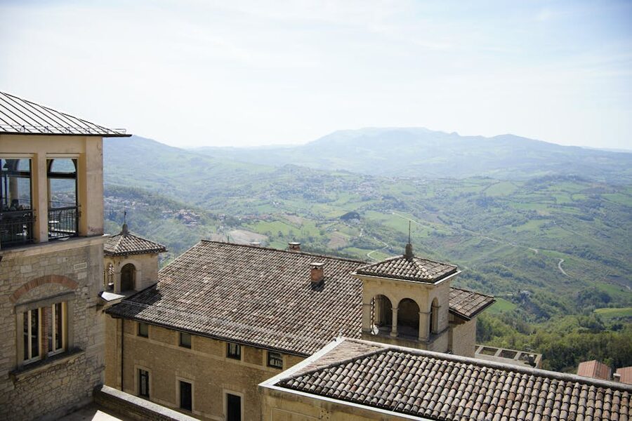 Panoramic view of terracotta rooftops and green Apennine hills from above Città di San Marino