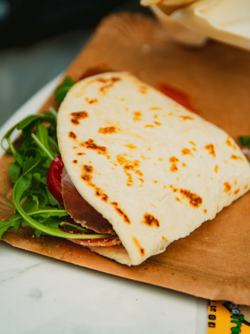 Piadina romagnola flatbread filled with prosciutto crudo, squacquerone and fresh rocket
